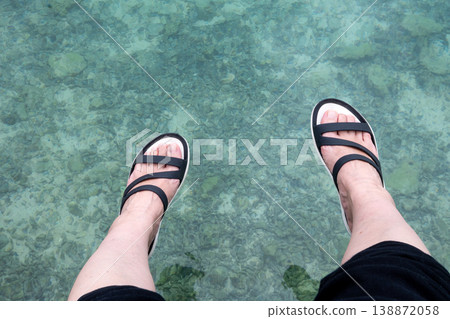 Women's feet entering the sea 138872058