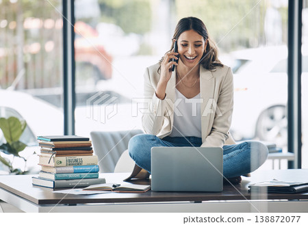 Worker, laptop and phone call laughing while sitting on desk in relax startup, marketing company or business. Happy smile, talking and woman on mobile communication technology, laptop or books study Worker, laptop and phone call laughing while sitting on desk in relax startup, marketing company or business. Happy smile, talking and woman on mobile communication technology, laptop or books study 138872077