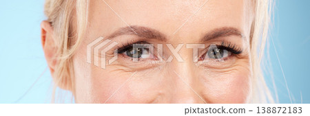 Closeup, eyes and old woman with skincare, cosmetics and wrinkles against blue studio background. Zoom, mature female and senior lady with eyecare, dermatology and beauty with wellness on backdrop Closeup, eyes and old woman with skincare, cosmetics and wrinkles against blue studio background. Zoom, mature female and senior lady with eyecare, dermatology and beauty with wellness on backdrop 138872183