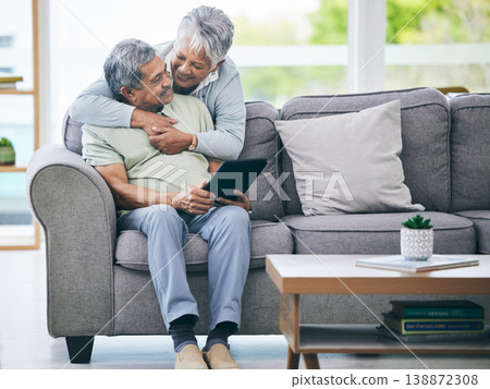 Tablet, couple and hug on sofa in home living room for love, care and quality time. Senior man, happy woman and embrace with digital technology for online shopping, social media and scroll internet 138872308