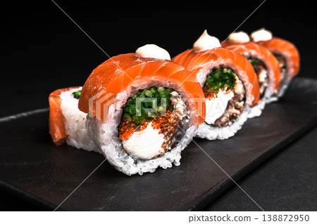 Delicious Fresh Salmon Sushi Rolls Presenting Exquisitely on a Black Background Delicious Fresh Salmon Sushi Rolls Presenting Exquisitely on a Black Background 138872950