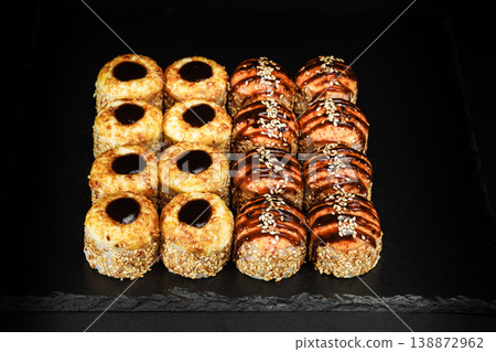 Delicious Fresh Sushi Rolls Presenting Exquisitely on a Black Background Delicious Fresh Sushi Rolls Presenting Exquisitely on a Black Background 138872962