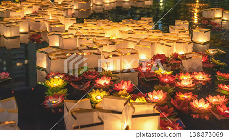 Lanterns floating on water, night festival with glowing lights, reflections, traditional celebration atmosphere, cultural event. Water lantern festival with light, spiritual ritual, night celebration 138873069