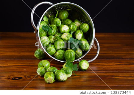 fresh brussels sprouts in metal colander on wooden table fresh brussels sprouts in metal colander on wooden table 138873444