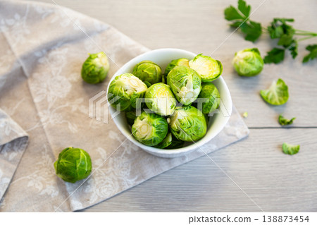 fresh brussels sprouts in bowl on wooden kitchen table background fresh brussels sprouts in bowl on wooden kitchen table background 138873454