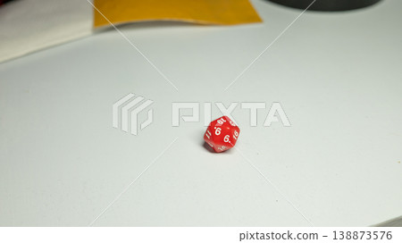 Red dice on white tabletop: d20 gaming die with numbers 6 and 19 Red dice on white tabletop: d20 gaming die with numbers 6 and 19 138873576