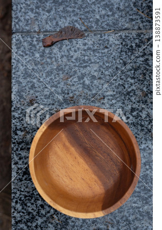 Wooden bowl on granite surface with leaf in outdoor setting Wooden bowl on granite surface with leaf in outdoor setting 138873591
