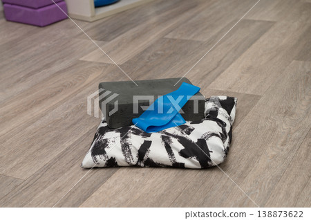 Yoga equipment on wooden floor featuring block, strap, and cushion Yoga equipment on wooden floor featuring block, strap, and cushion 138873622