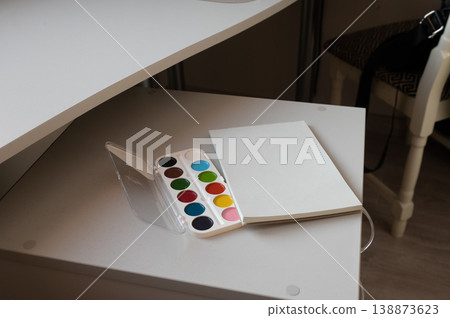 Watercolor set and blank sketchbook on white desk Watercolor set and blank sketchbook on white desk 138873623
