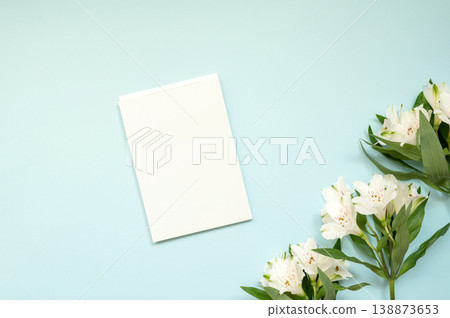 Blank white card on light blue background with white flowers Blank white card on light blue background with white flowers 138873653