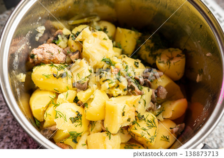 Boiled potatoes mixed with herbs in stainless pot on countertop Boiled potatoes mixed with herbs in stainless pot on countertop 138873713