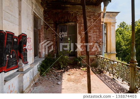 Graffiti walls contrast with rusted structures and lush plants 138874403