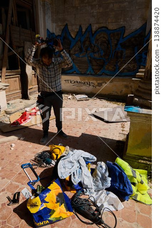 Distressed man salvaging belongings in derelict interior Distressed man salvaging belongings in derelict interior 138874420