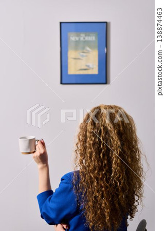 Quiet lady in blue blazer sips tea amid warm morning light 138874463