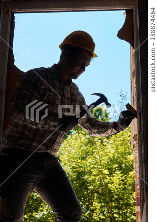 Construction professional inspects transparent surface within foliage 138874464