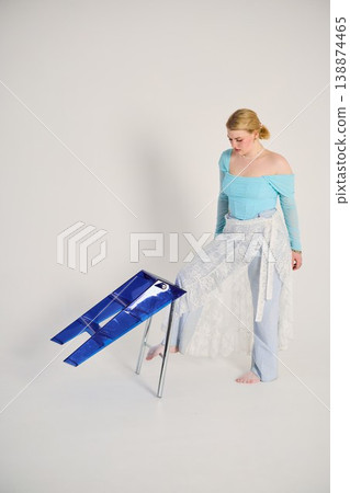 Serene female in blue attire. Tranquil lady dressed in blue on steps Serene female in blue attire. Tranquil lady dressed in blue on steps 138874465