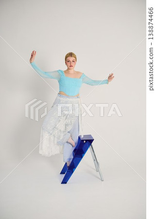 Charming female model strikes pose with flowing skirt and pastel clothes Charming female model strikes pose with flowing skirt and pastel clothes 138874466