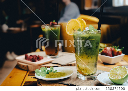 Frozen lemon tea with added matcha in a glass, standing on a wooden table in a cafe Frozen lemon tea with added matcha in a glass, standing on a wooden table in a cafe 138874500