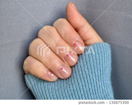 spring manicure for short nails with highlights and a small design at home, a girl's hand on a monochrome background spring manicure for short nails with highlights and a small design at home, a girl's hand on a monochrome background 138875300