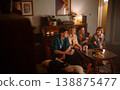 Friends enjoy a cozy evening gathering together, relishing tasty snacks and drinks 138875477