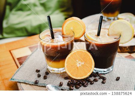 A glass of Espresso Sunrise on a coffee table, decorated with slice of orange. Refreshing and energizing drinks for a hot summer day, natural light, minimal composition, vibrant lifestyle scene. A glass of Espresso Sunrise on a coffee table, decorated with slice of orange. Refreshing and energizing drinks for a hot summer day, natural light, minimal composition, vibrant lifestyle scene. 138875624