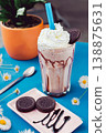 Chocolate smoothie with a creamy flavor in a glass on a wooden table, decorated with  chocolate cookies, healthy summer drink, vibrant colors, natural light. 138875631