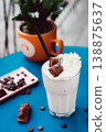 Smoothie with a creamy flavor in a glass on a wooden table, decorated with  chocolate wafer, healthy summer drink, vibrant colors, natural light. 138875637