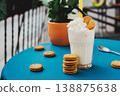 Vanilla smoothie in a glass on a wooden table, decorated with oat caramel cookies, healthy summer drink, vibrant colors, natural light. 138875638