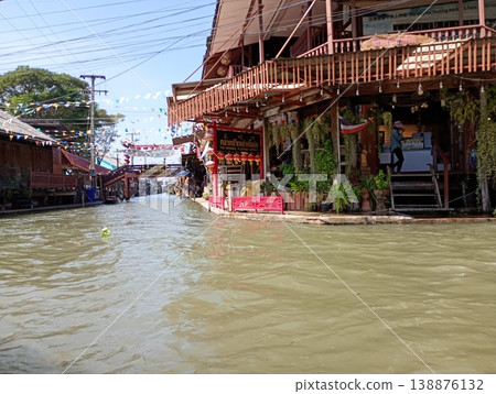 A scene of a floating market in Thailand and shops lining the canal. A scene of a floating market in Thailand and shops lining the canal. 138876132