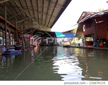 A scene of a floating market in Thailand and shops lining the canal. A scene of a floating market in Thailand and shops lining the canal. 138876135