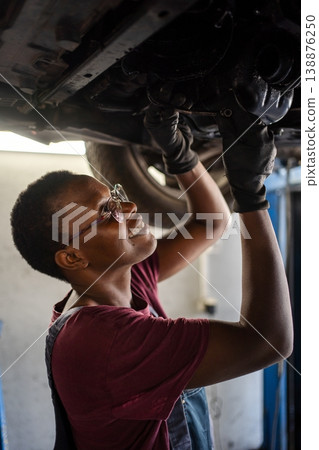 Young female mechanic repairing car in a garage Young female mechanic repairing car in a garage 138876250