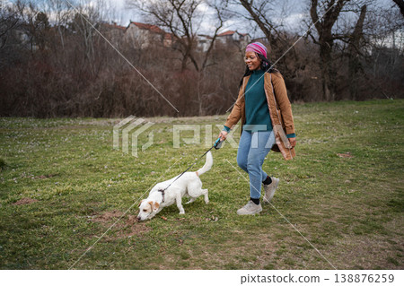 Woman walking dog discovering smells in park 138876259