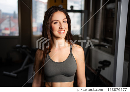 Young woman smiling in gym representing fitness goal 138876277