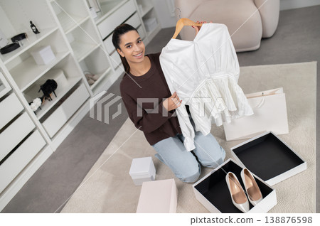 Pretty female fashion vlogger presenting a new fashion collection online and looking excited Pretty female fashion vlogger presenting a new fashion collection online and looking excited 138876598