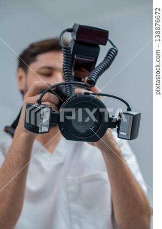 Male dentist making a photo of his work result Male dentist making a photo of his work result 138876672
