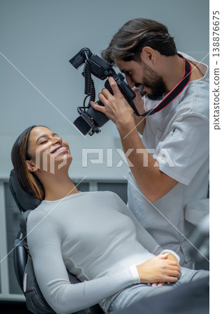 Male dentist making a photo of his work result Male dentist making a photo of his work result 138876675