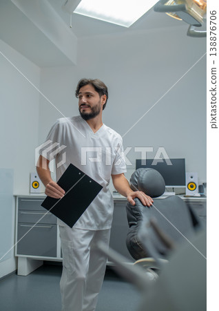 Young caucasian dentist in lab coat looking confident and contented Young caucasian dentist in lab coat looking confident and contented 138876706