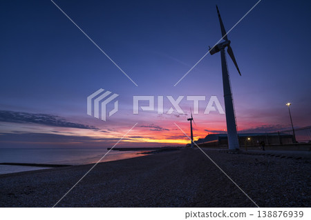 Sunset along coast with pair of land-based wind turbines Sunset along coast with pair of land-based wind turbines 138876939