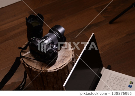 Camera rests atop rustic wooden stump 138876995