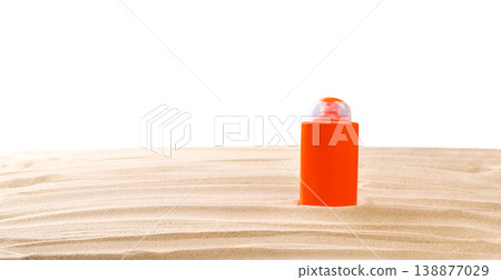Bottle of sunscreen cream on sand beach isolated on a white background. Bottle of sunscreen cream on sand beach isolated on a white background. 138877029