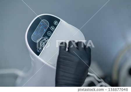 Close up of a medical device and a hu,an hand in black glove switching it Close up of a medical device and a hu,an hand in black glove switching it 138877048
