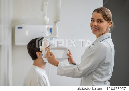 Portrait of smiling dental assistant with x-ray machine 138877057