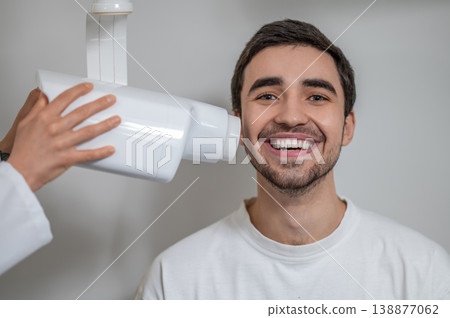 Patient smiling during dental x-ray examination Patient smiling during dental x-ray examination 138877062