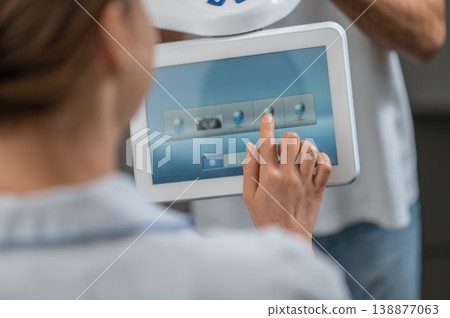 Dental assistant finger touching digital screen 138877063
