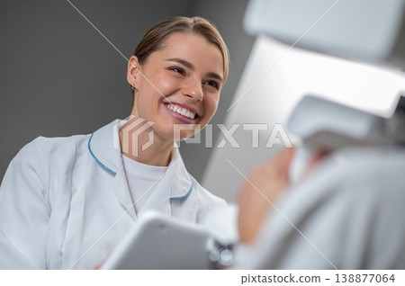 Happy female doctor working with digital device 138877064