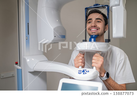 Smiling man undergoing panoramic dental x-ray Smiling man undergoing panoramic dental x-ray 138877073