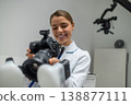 Female doctor checking settings on photo camera 138877111