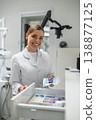 Female dentist holding packed tool and smiling 138877125
