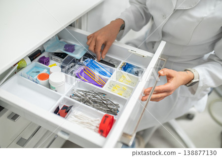 Female assistant opening drawer with supplies Female assistant opening drawer with supplies 138877130
