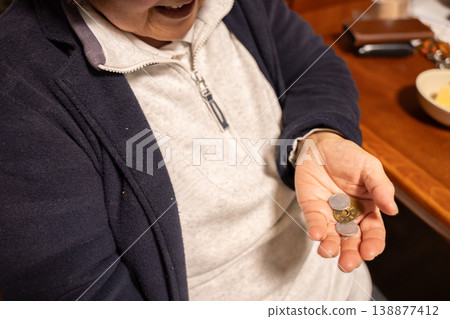 一位老婦人把手裡的錢放進手上 一位老婦人把手裡的錢放進手上 138877412